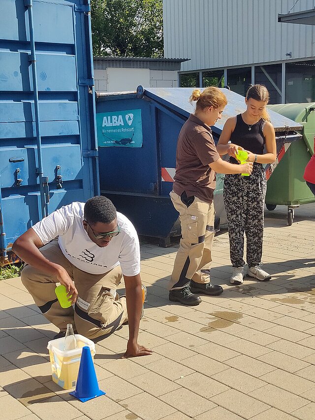 Drei Menschen spielen ein Wasserspiel