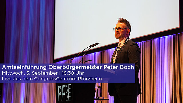 Farbfoto: OB Peter Boch steht im CCP auf der Bühne am Mikrofon
