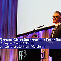 Farbfoto: OB Peter Boch steht im CCP auf der Bühne am Mikrofon
