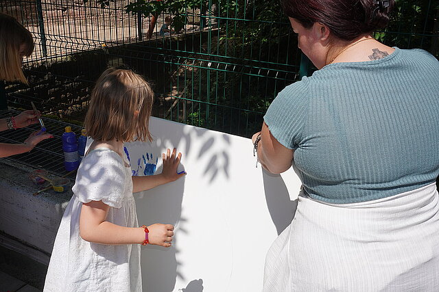 Ein Mädchen macht einen Fingerfarbenabdruck ihrer Hand - copyright:Stadt Pforzheim