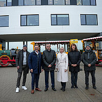 6 Personen stehen vor einem Bähnchen