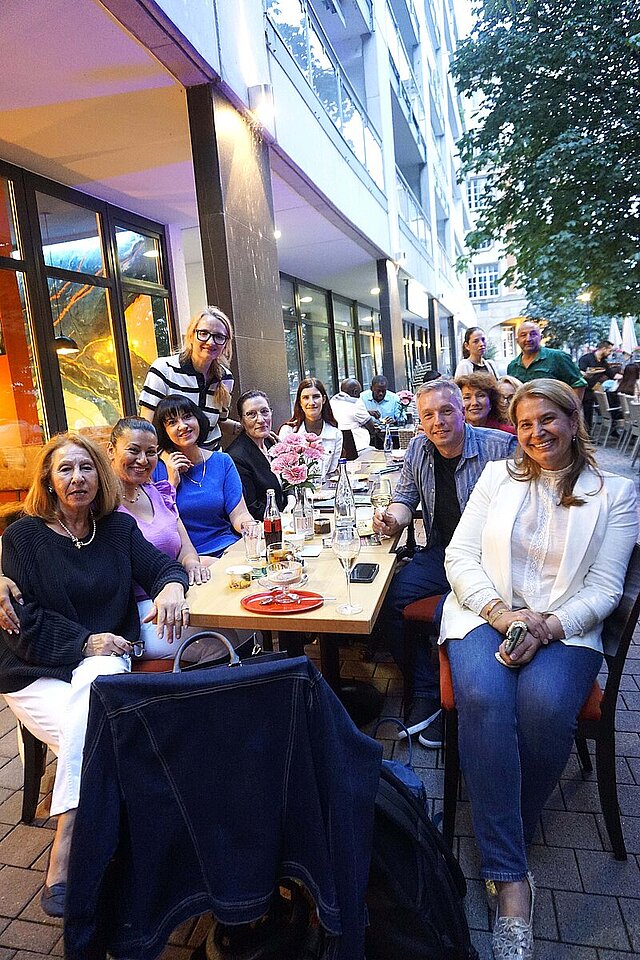 Mitglieder des Internationalen Beirats sitzen draußen an einem Wirtshaustisch