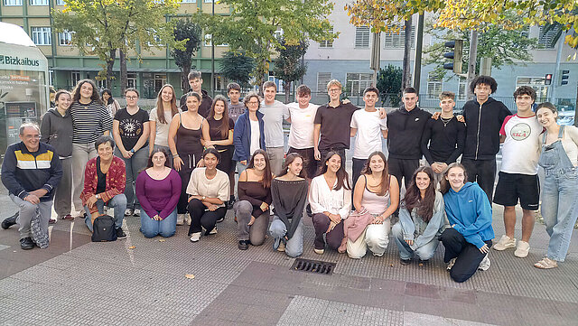 Ein Gruppenfoto mit mehreren Schülerinnen und Schülern vor einer Schule in Gernika