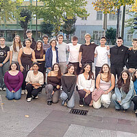 Ein Gruppenfoto mit mehreren Schülerinnen und Schülern vor einer Schule in Gernika