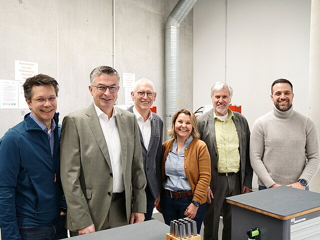 Fünf Männer und eine Frau stehen nebeneinander