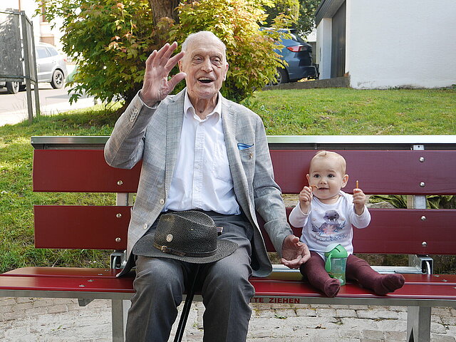 Senior Kurt Götz und Baby Jacksen Hertweck freudig auf der neuen Bank