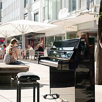 Farbfoto: Schwarzes Klavier steht in der Innenstadt