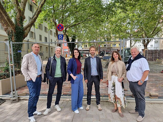 6 Personen stehen vor grünen Bäumen