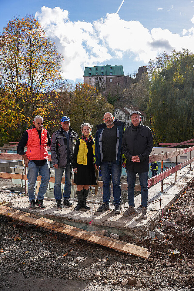 Gerold Haas, bauatelier freie Architekten Haas und Hiesch, Georg Busch, Fachbereichsleiter Bäderbetriebe im Eigenbetrieb Pforzheimer Verkehrs- und Bäderbetriebe (EPVB), Ute Hiesch, bauatelier freie Architekten Haas und Hiesch sowie Projektleiter Bernd Hagenbuch und der Werkleiter des EPVB, Bernd Mellenthin stehen vor dem Becken des Nagoldbades, das gerade eine Baustelle ist.