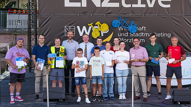 Menschen stehen auf einer Bühne und schauen in die Kamera