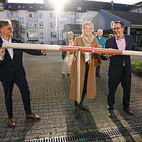Auf dem Bild sind Oberbürgermeister Peter Boch, Stadtbau-Geschäftsführerin Barbara Früh und Bürgermeister Tobias Volle zu sehen, die eine Schranke hochheben und damit den Parkplatz auf dem Gelände des ehemaligen Lidl-Marktes an der Hohenzollernstraße für das öffentliche Parken freigeben.
