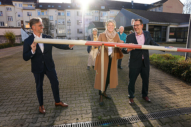 Auf dem Bild sind Oberbürgermeister Peter Boch, Stadtbau-Geschäftsführerin Barbara Früh und Bürgermeister Tobias Volle zu sehen, die eine Schranke hochheben und damit den Parkplatz auf dem Gelände des ehemaligen Lidl-Marktes an der Hohenzollernstraße für das öffentliche Parken freigeben.