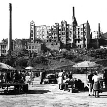 1948: Der Wochenmarkt auf dem Turmplatz. Im Hintergrund sind die vom kriegszerstörten Häuserruinen auf der Wilhelmshöhe zu sehen. (Schwarz-Weiß-Fotografie) - copyright:Stadtarchiv Pforzheim – Institut für Stadtgeschichte, S1-18-2-0-G-15