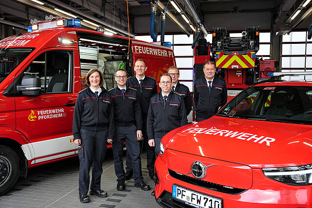 Gruppenbild von Verantwortlichen der Feuerwehr bei Übergabe des neuen vollelektrischen Kommandowagens und neuen Kleineinsatzfahrzeugs