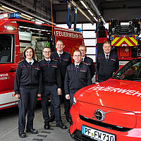 Gruppenbild von Verantwortlichen der Feuerwehr bei Übergabe des neuen vollelektrischen Kommandowagens und neuen Kleineinsatzfahrzeugs