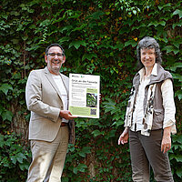 Tobias Volle und Sylvia Lorenz stehen vor einer grünen Fassade