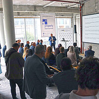 Farbfoto: Menschen sehen sich eine Präsentation an