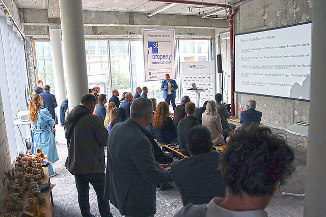 Farbfoto: Menschen sehen sich eine Präsentation an