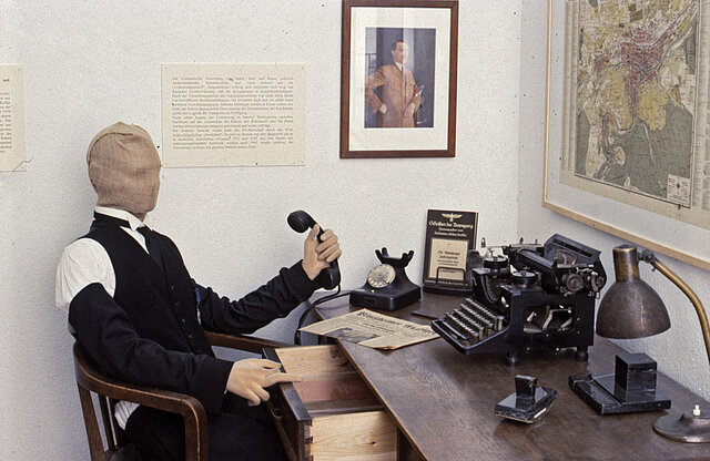 Ausstellung: Arbeitsplatz 30er Jahre mit Hitlerbild an der Wand