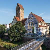 Farbfoto: EMMA Kreativzentrum von Außen mit Portraits auf der Fassade und dem Gehweg