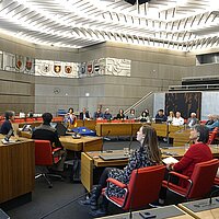 Farbfoto: Mehrere Leute sitzen im Großen Sitzungssaal