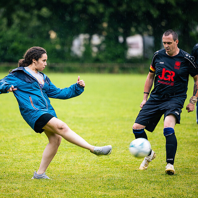 Eine Frau schießt den Fußball weg. Eine Person im schwarzen Trikot versucht den Ball zu blocken. - copyright:Stadt Pforzheim