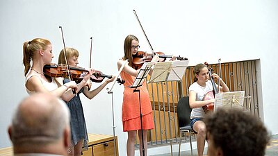 Schülerinnen spielen Streichinstrumente