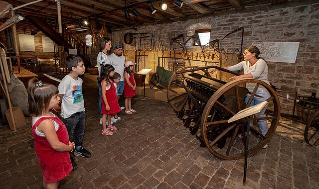 Unsere Museumspädagogin erklärt die landwirtschaftlichen Geräte