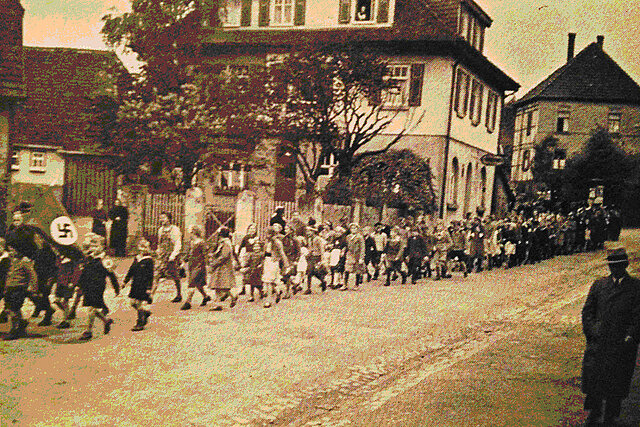 Dieses Bild zeigt einen Schülermarsch mit Hakenkreuz während der NS-Zeit in Büchenbronn.