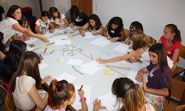 Mädchen sitzen am Tisch und schreiben