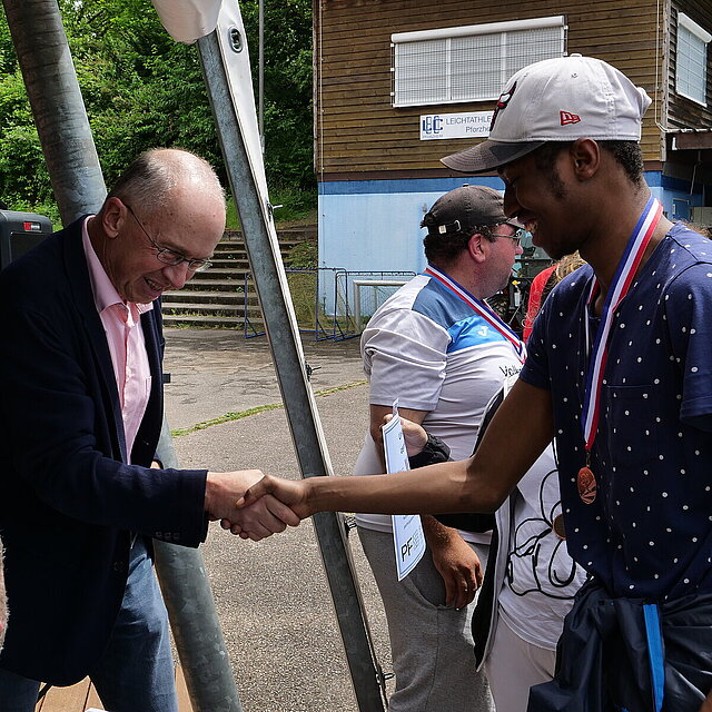 Herr Fillbrunn überreicht einem jungen Mann eine Medaille und schüttelt ihm die Hand. - copyright:Stadt Pforzheim