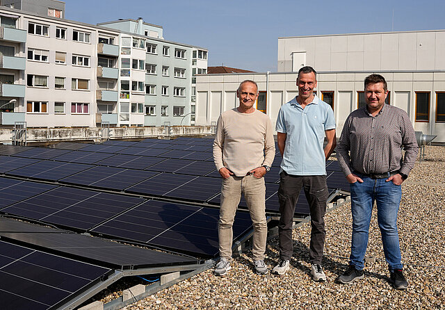 Rainer Störzenecker, Sachgebietsleitung Technische Gebäudeausrüstung im Gebäudemanagement, Stephan Bürkle, Feuerwehr Pforzheim und Jan Kühner, Projektleiter der technischen Gebäudeausrüstung stehen auf dem Dach der Hauptfeuerwache in Pforzheim vor der neu errichteten Photovoltaikanlage.