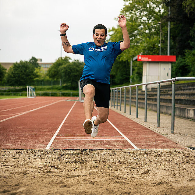 Ein Mann befindet sich während eines Sprungs in der Luft. Er wird in einer Sandgrube landen. - copyright:Stadt Pforzheim