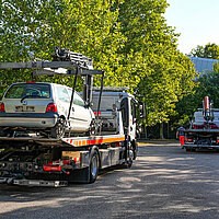 Farbfoto: Abschleppwagen mit aufgeladenem Kleinwagen