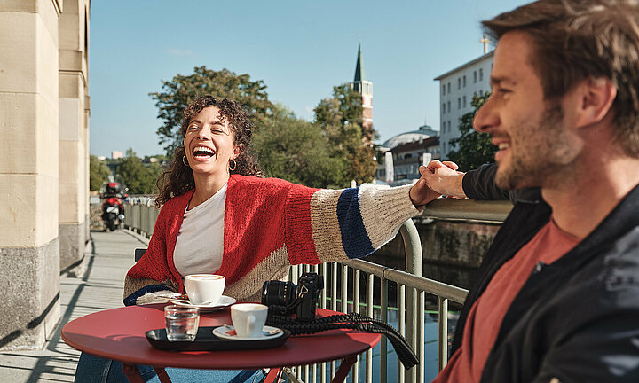 Ansicht von Cafe - Mann und Frau am Tisch lachend 