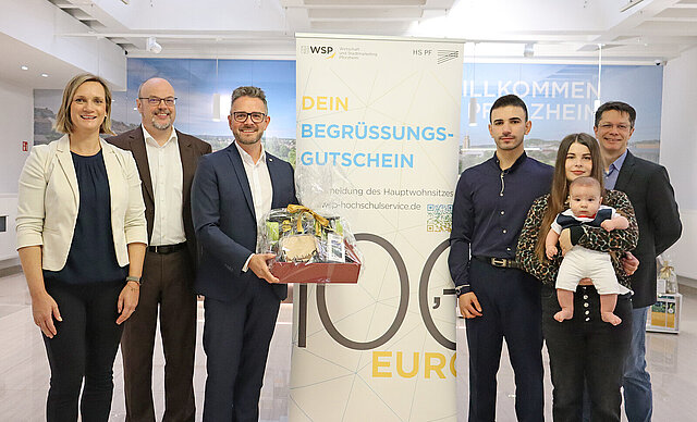 Farbfoto: v.l.n.r.: Freuen sich über die Ausgabe des 250. Begrüßungsgutschein für Studierende: Miriam Fieser, Prof. Dr. Frank Niemann, Oberbürgermeister Peter Boch, Student Rafat Khaled mit Partnerin Diana Kostrova und Sohn Amir sowie Markus Epple.