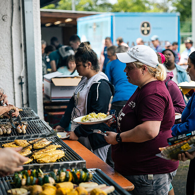 Vor vier Grills stehen Personen und warten auf Grillgut. - copyright:Stadt Pforzheim