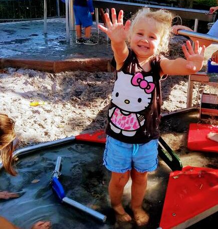 Bild: Lachende Kind auf dem Wasserspielplatz
