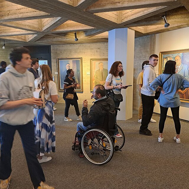 Zehn Personen schauen sich in der 6. Etage im Rathaus Pforzheim die Portraits der ehemaligen Bürgermeister an. - copyright:Stadt Pforzheim