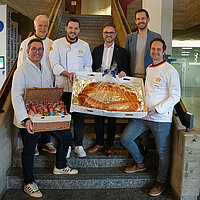 Gruppenbild bei Übergabe der diesjährigen Neujahrsgaben auf Eingangstreppe des neuen Rathauses