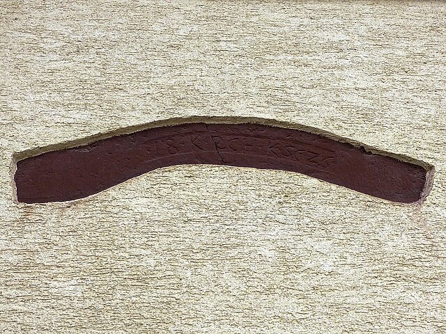 Farbfotografie des Baujahres aus dem alten Gebäude, in die Außenmauer verputzt - copyright:denk mal!-Tour Hohenwart