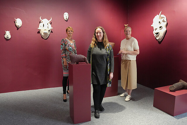 Kulturamtsleiterin Angelika Drescher, Künstlerin Sonja Keppler und Kuratorin Regina M. Fischer vor Skulpturen und Masken
