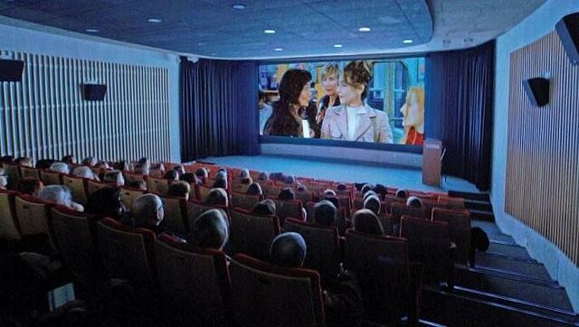 Kinosaal (Filmleinwand mit Sitzreihen, auf denen Menschen sitzen und den Film schauen)