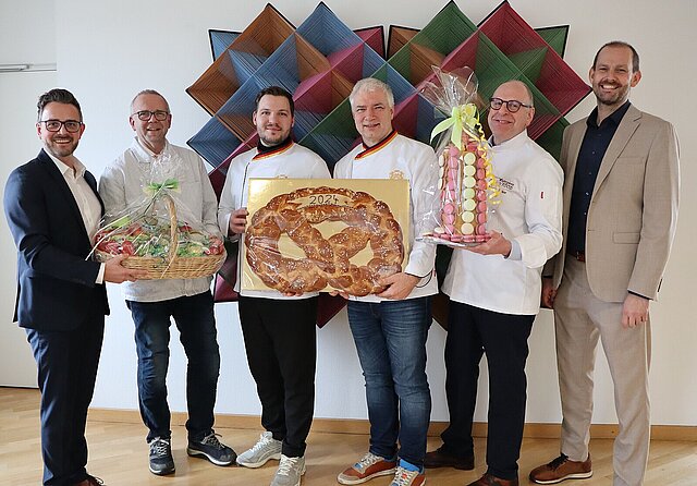 Landrat Bastian Rosenau (rechts), Pforzheims OB Peter Boch (links) sowie (von links nach rechts) Andreas Beier, Jannis Wiskandt, Martin Reinhardt und Johannes Becker als Vertreter der Innungen bei der Überreichung der diesjährigen Neujahrsgaben im Landratsamt.