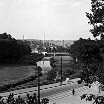 Black and white photo from 1929: View of the Nagold valley: the factory chimneys in the town centre can be seen in the background. - copyright:Stadtarchiv Pforzheim – Institut für Stadtgeschichte, S1-10-2-R-61