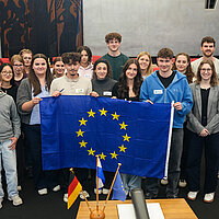 Viele Personen, die eine Europa-Flagge in der Hand halten.