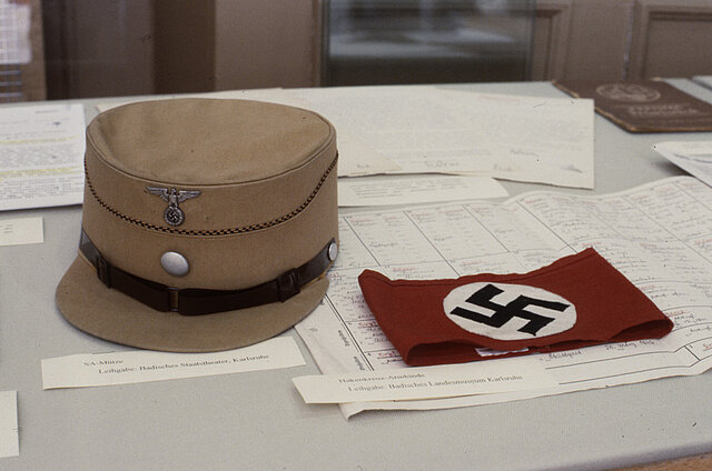 Foto aus der Ausstellung: SA-Mütze und Hakenkreuzarmbinde