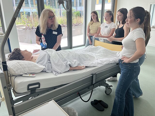 Susanne Pröll, Schulleiterin des Siloah Bildungszentrums für Pflegberufe demonstriert an einer lebensechten Puppe das Verabreichen einer Injektion.