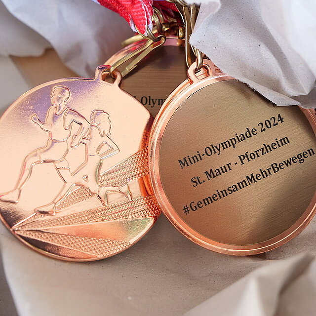 Auf dem Foto ist die Vorderseite und Rückseite einer bronzenen Medaille zu sehen, die an der Mini-Olympiade verteilt wurden. - copyright:Stadt Pforzheim