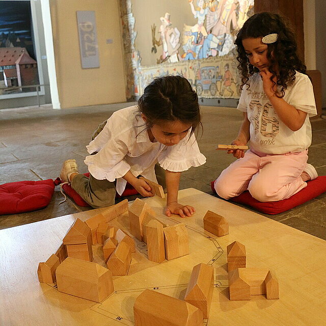 Kinder bauen mithilfe eines großen Holzpuzzles das mittelalterliche Pforzheim nach. - copyright:Stadt Pforzheim